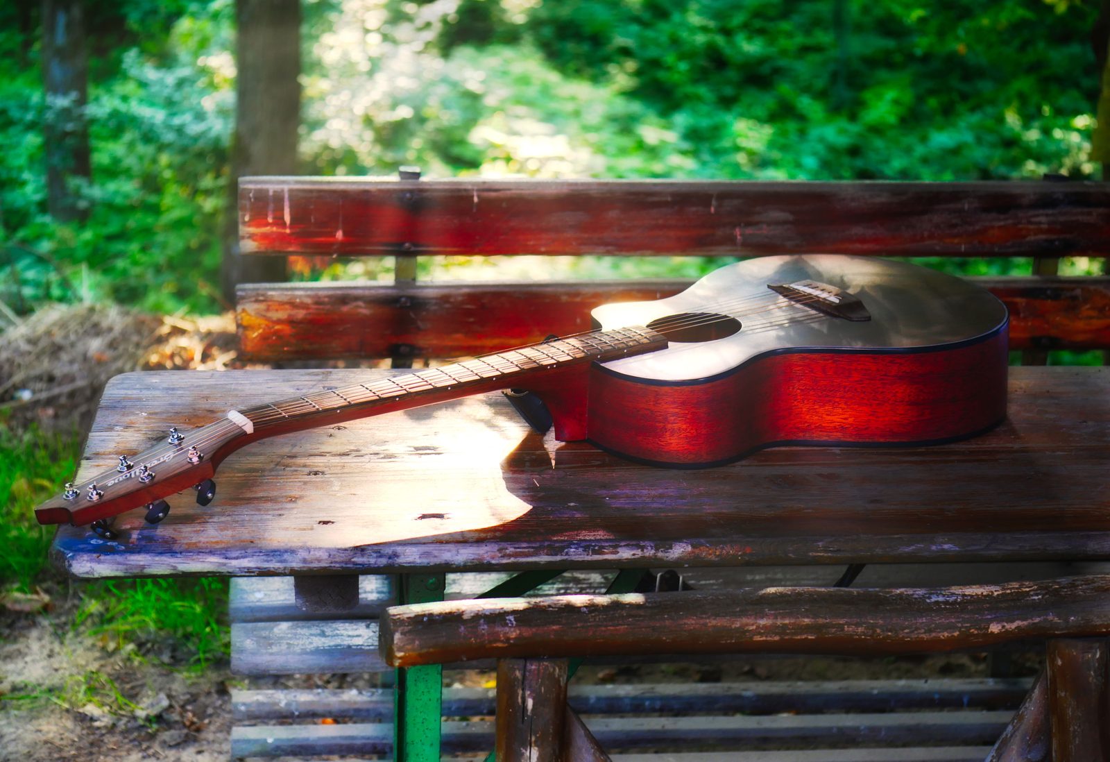 Gitarre auf einer Bank im Grünen